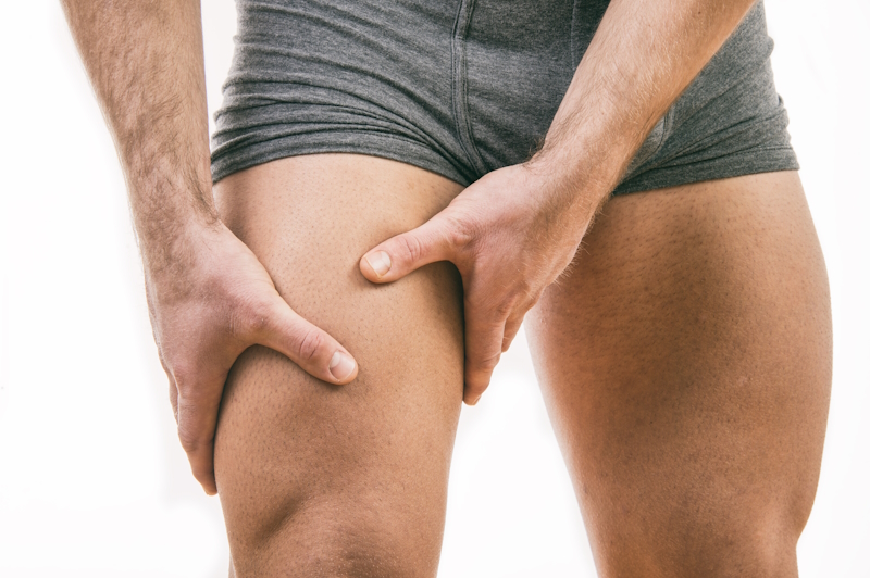 young male holding thigh due to quadriceps muscle tear